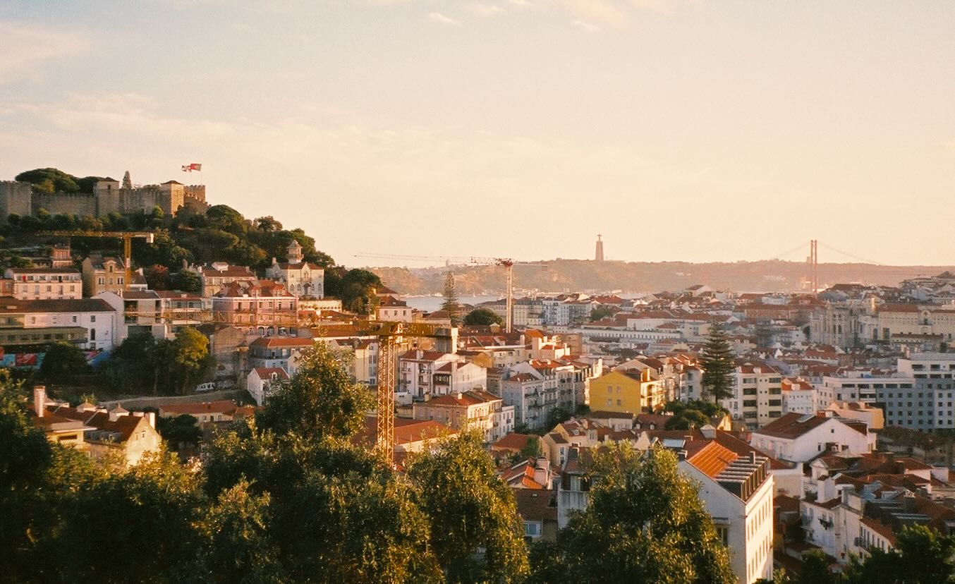 Sunset over the rooftops and hills of lisbon from miradouro da senhora do monte.
